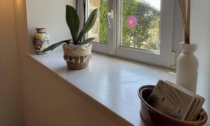 A window sill with a potted plant, a decorative vase, and a small bowl. - Rental for 2 With Private Outdoor Space (Plougasnou)