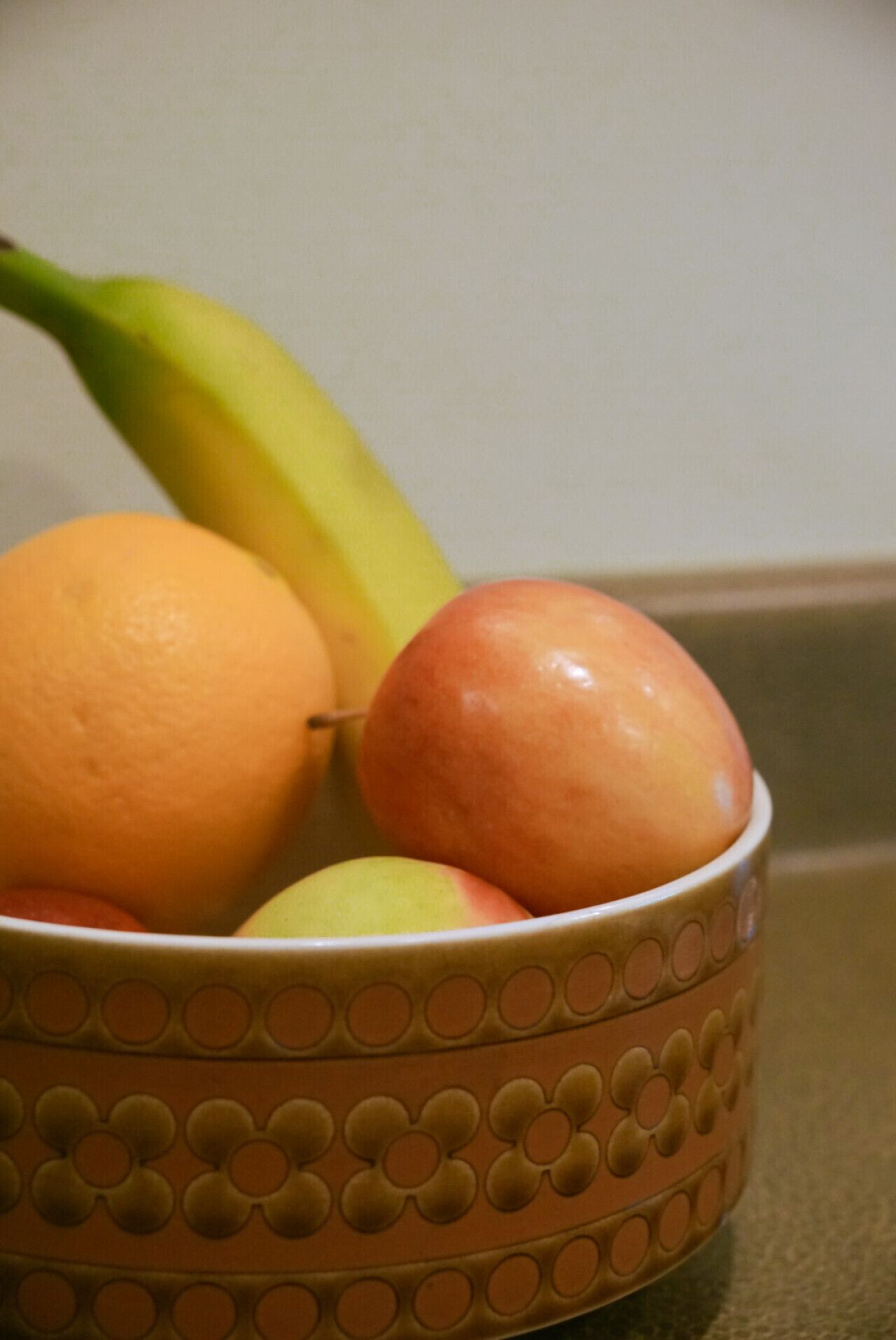 A bowl with a patterned design containing fruits.
