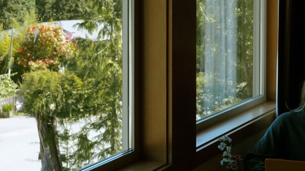 Ein Zimmer mit großem Fenster, Tisch und Stuhl.