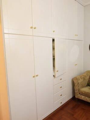 A room with a wardrobe, a sofa, and a wooden floor. - Charming Glyfada Family Appartment close to the Beach & City center | Quiet Area (Glifada)