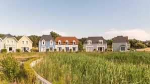 Een rij huizen met een grasveld voor.