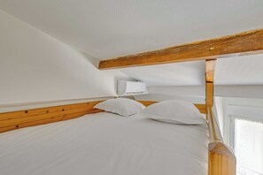 A bedroom with a wooden headboard, white bedding, and a window with curtains. - Studio 2P Near Tolbiac / Olympiades (Paris)