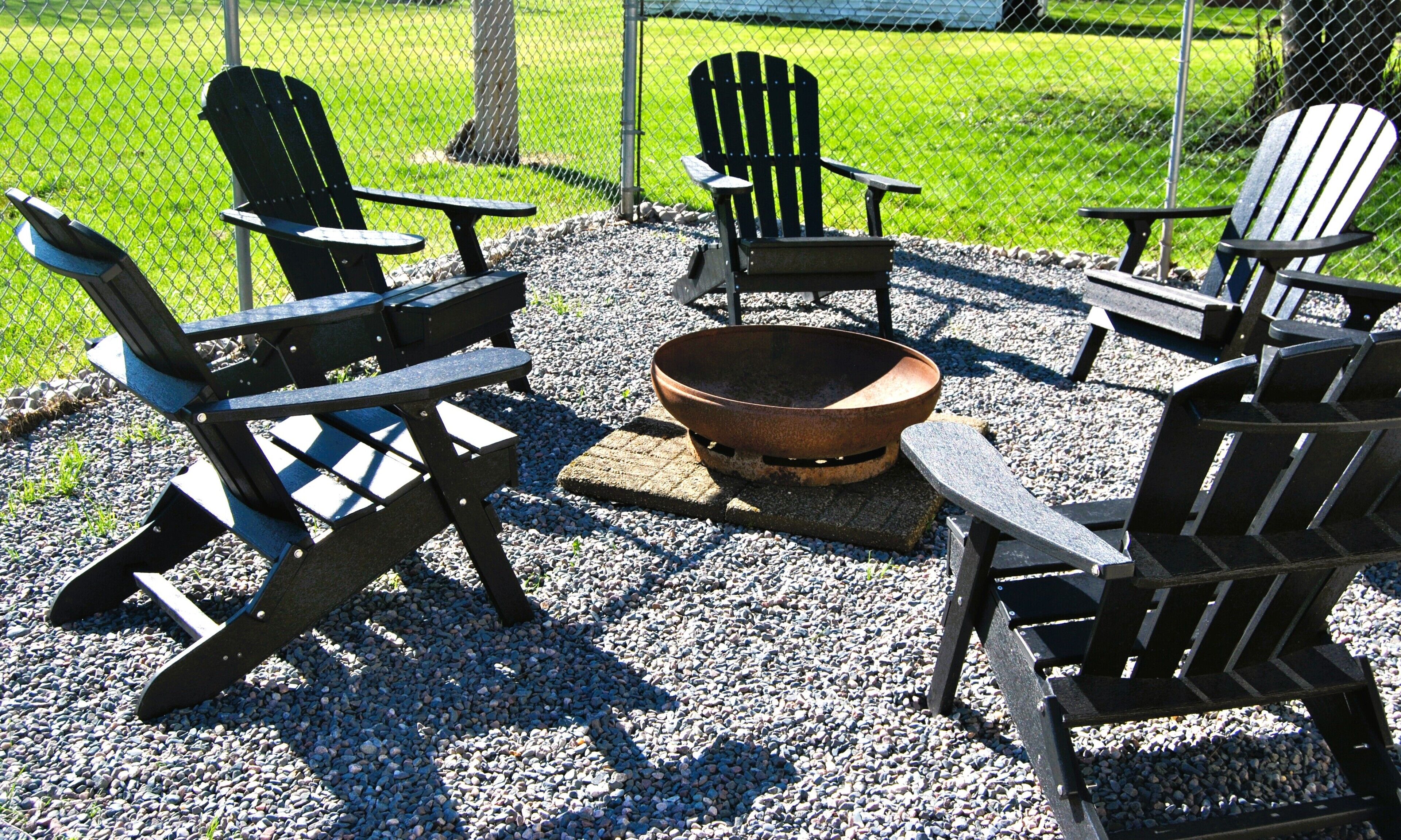 Outdoor backyard, Adirondack chairs, fire pit, gas grill, table & chairs. 