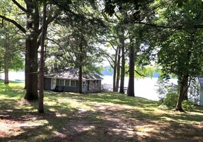 A cabin by a lake surrounded by trees.