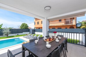 A balcony with a pool, dining table, chairs, and a tray of fruit. - 6-person Home With 3 En-suites (Novigrad)