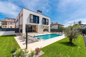 A modern two-story house with a swimming pool, a covered patio, and a well-maintained lawn. - 6-person Home With 3 En-suites (Novigrad)