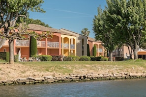 Un hotel con piscina, zona de estar al aire libre y vistas al agua.