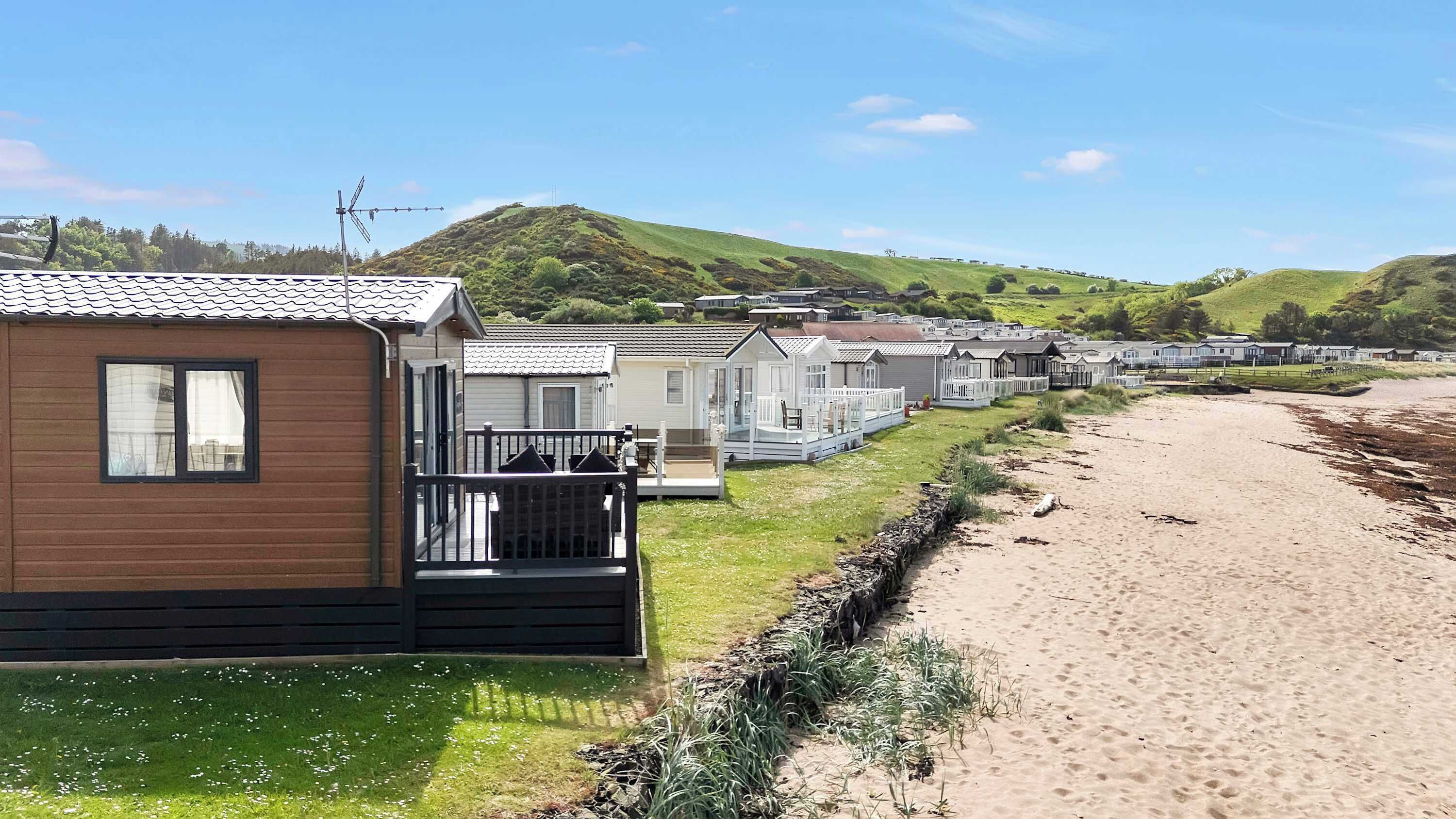 A row of mobile homes with a beach in the background.