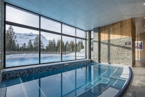 An indoor swimming pool with a view of snow-capped mountains and trees. - Mountain View Retreat With Balcony for 8 (Araches-la-Frasse)