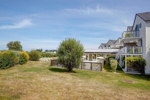 A residential area with houses, a lawn, and a fence. - Elegant 4-pax Apartment With River View (Courseulles-sur-Mer)