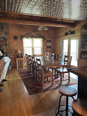 A dining area with a wooden table, chairs, and a bar counter.