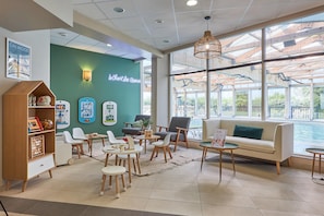 A reception area with a green wall, wooden furniture, and a view of the outdoors. - Courseulles Family Apartment for 6 (Courseulles-sur-Mer)