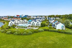 Ett bostadsområde med hus längs en flod, där modern och traditionell arkitektur blandas.