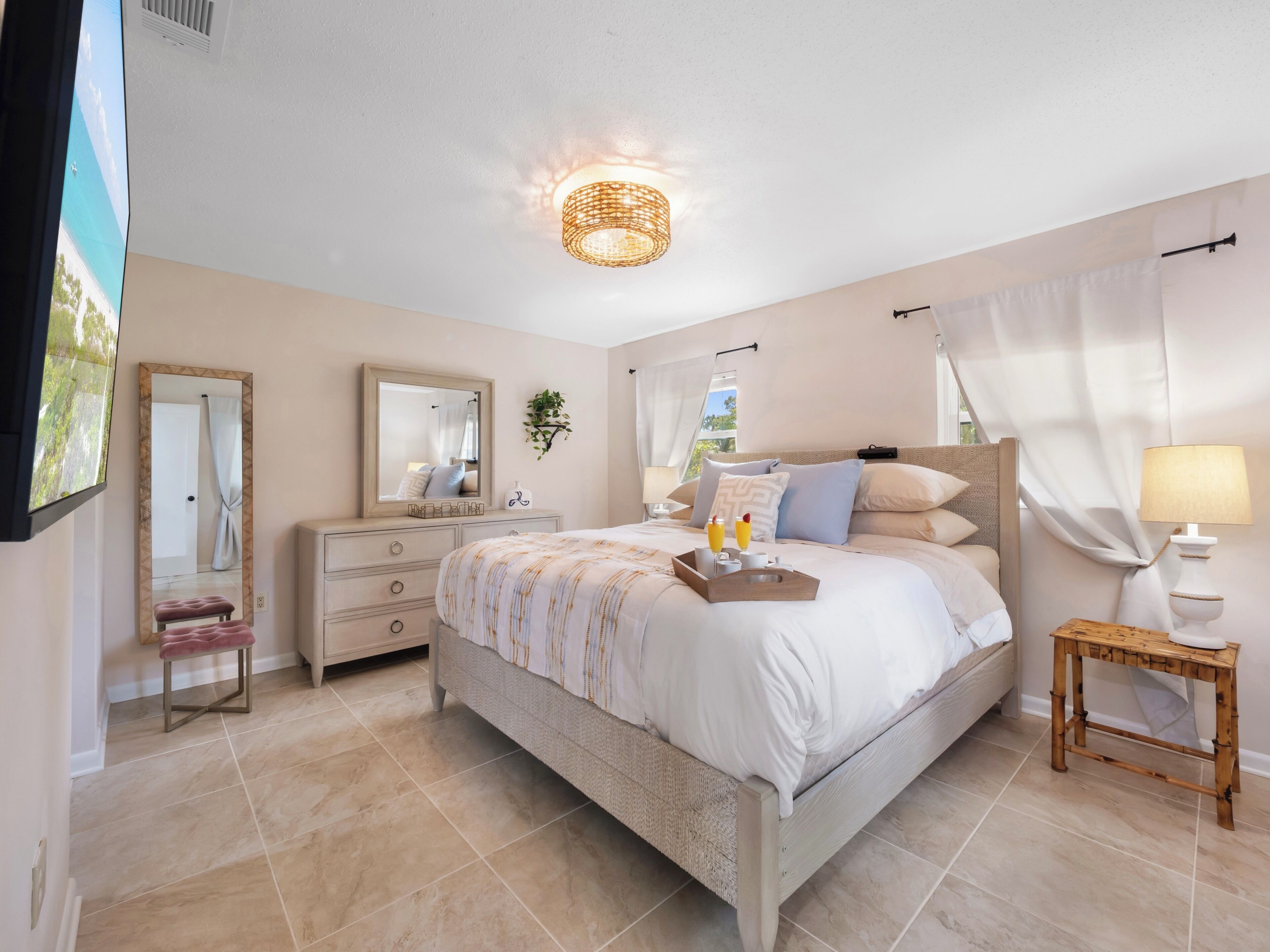 A bedroom with a bed, bedside table, lamp, and a mirror.