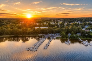 A marina with boats docked, surrounded by trees and buildings.