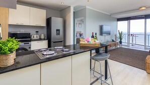 Een moderne keuken met een centraal eiland, inbouwapparatuur en een eetgedeelte met uitzicht.