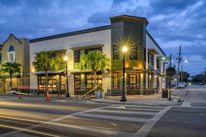 A modern building with a cafe on the ground floor, a street view, and a crosswalk.