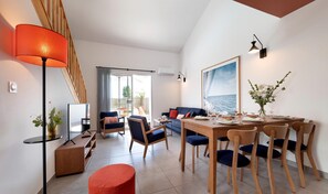 A modern living room with a TV, sofa, dining table, and chairs. - Picturesque 6-person Duplex Oasis (Les Sables-d'Olonne)