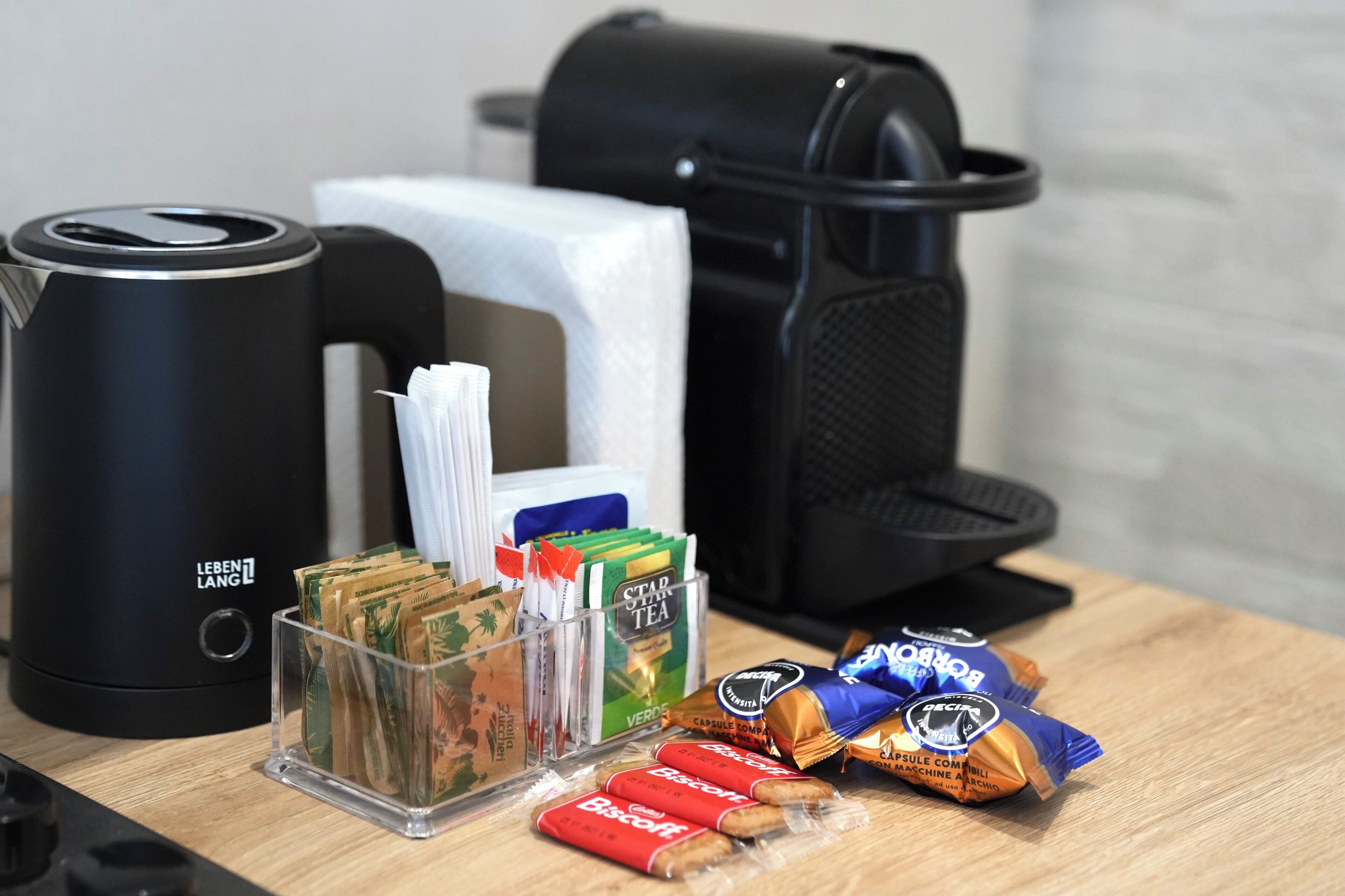 A coffee maker, a tissue box, a trash bin, and snacks on a table.