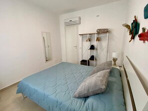 A bedroom with a bed, a wardrobe, a mirror, and a wall-mounted air conditioner. - Katy's Holiday House, Private Villa (Sicilia)