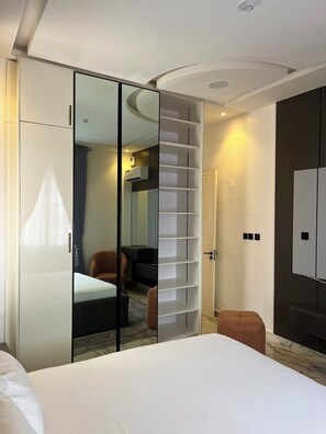 Ein Hotelzimmer mit Bett, Kleiderschrank, Sitzecke und Spiegel.