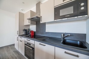 A modern kitchen with a Bosch microwave, a coffee maker, and a sink. - Corsica Haven With Garden (Lecci)