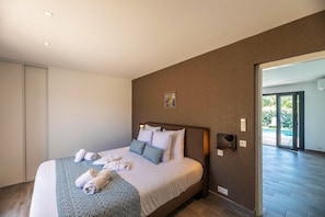 A modern hotel room with a large bed, a view of the outdoors, and a sliding door leading to a balcony. - Corsica Haven With Garden (Lecci)