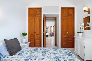 Ein Schlafzimmer mit einem Bett, einem Nachttisch, einer Kommode und einem großen Holzschrank.