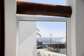 Ein Fenster mit Blick auf eine Stadtansicht, darunter Gebäude und eine Straßenlaterne.