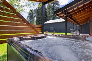 Un área de jacuzzi con terraza de madera y zona cubierta para sentarse.