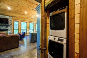 Ein Holzinnenraum mit Kamin, einer Couch und einer Waschmaschine.