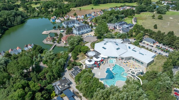 A resort with a swimming pool, a water slide, and a large building with a flat roof. - House Near the Lake and Golf Course (Fort-Mahon-Plage)