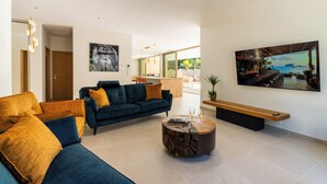 En moderne stue med sofa, sofabord og billedkunst på væggene.