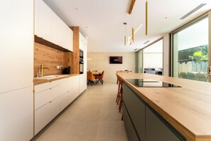 Eine moderne Küche mit Holzelementen, einem Essbereich und einem großen Fenster.