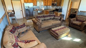 A spacious living area with a large sofa set, a kitchen with wooden cabinets, and a ceiling fan. - Perfect 2-bedroom apartment in wonderful Wyarno for your stay (Wyarno)
