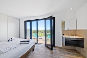 A bedroom with a bed, a bathroom with a sink, and a balcony with chairs. - Sun-drenched Corsican Flat (Lecci)