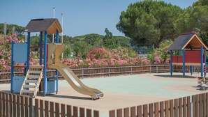 Ein Spielplatz mit Rutsche, Klettergerüsten und einem eingezäunten Bereich.