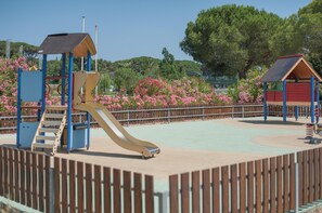A playground with a slide, climbing structures, and a fenced area. - Riverfront Oasis Near the Beach (Mandelieu-La-Napoule)