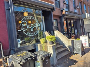 A storefront with a large window displaying the name "Nagle's Bagels Bed-Studio".