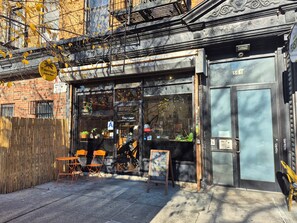 A storefront with a sign reading "Tamar" and a menu board outside. - Elegant 1-bedroom apt. in a Classic Brooklyn Brownstone with private backyard (Brooklyn)