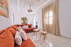 Ein modernes Wohnzimmer mit einer Couch, einem runden Couchtisch und einem Gemälde an der Wand.