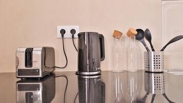 Eine Küchenarbeitsplatte mit einem Toaster, einem Wasserkocher und einer Utensilienhalterung.