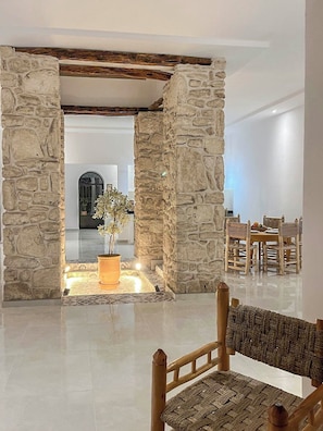 A stone-framed doorway leading to a dining area with a table and chairs.