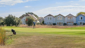 En golfbana med hus i bakgrunden.