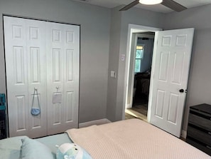 A bedroom with a bed, a wardrobe, and a door leading to another room.