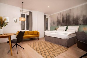 A modern hotel room with a bed, a sofa, a desk, and a large window. - Faraway Homes Studio Semmering #305 (Spital am Semmering)