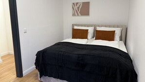 A bedroom with a bed, a headboard, a wall-mounted artwork, and a door. - Faraway Homes Studio Semmering #302 (Spital am Semmering)