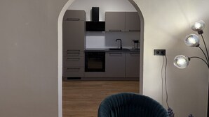 A modern kitchen with an archway leading to it, a dishwasher, oven, and a sink. - Faraway Homes Studio Semmering #304 (Spital am Semmering)