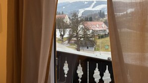 A window with a view of a town, including buildings and a mountain. - Faraway Homes Studio Semmering #304 (Spital am Semmering)