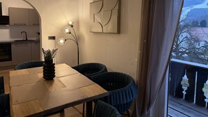 A dining area with a table, chairs, a vase, and a wall-mounted light fixture. - Faraway Homes Studio Semmering #304 (Spital am Semmering)